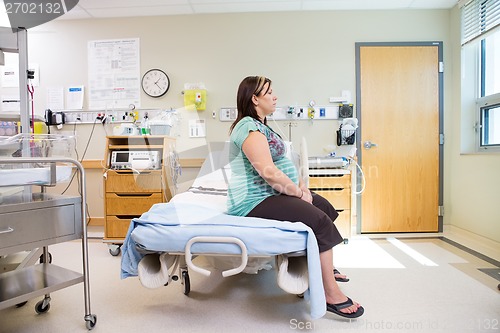 Image of Thoughtful Pregnant Woman Sitting On Hospital Bed