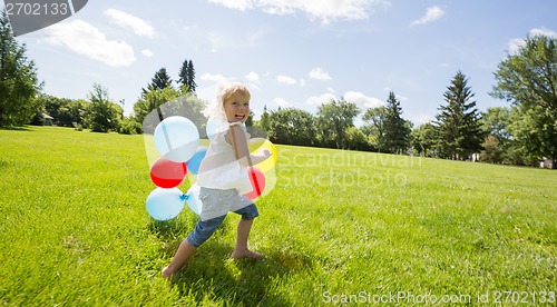 Image of Girl With Colorful Balloons Running In Meadow