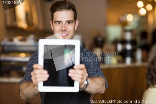 Image of Cafe Owner Holding Digital Tablet In Restaurant