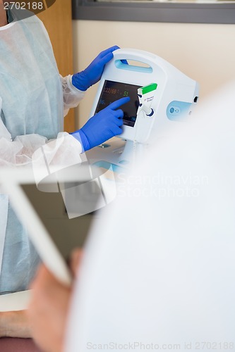 Image of Nurse Operating Heartbeat Machine In Hospital