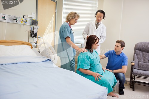 Image of Medical Team And Man Looking At Pregnant Woman In Hospital