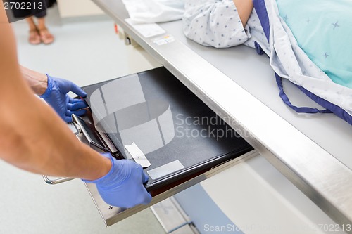 Image of Nurse Adjusting Film In Xray Table