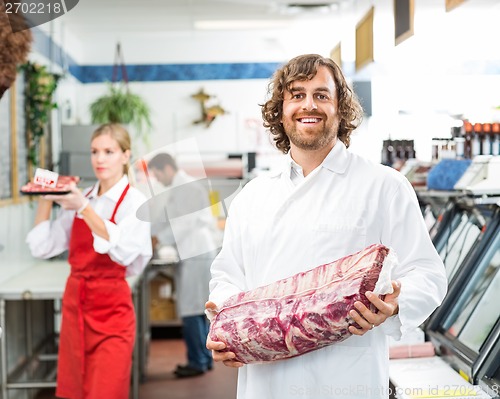 Image of Portrait Of Happy Butcher Holding Meat Package