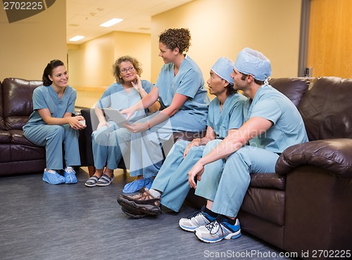 Image of Doctor Showing Digital Tablet To Team