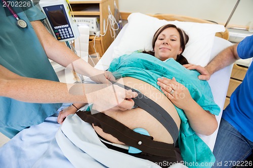 Image of Nurse Attaching Fetal Monitor to Birthing Mother