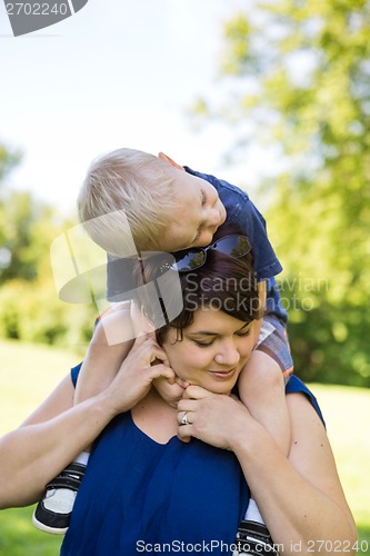 Image of Mother Carrying Son On Shoulders In Park