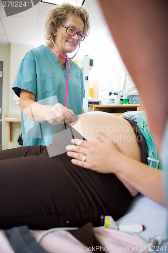 Image of Nurse Examining Pregnant Woman With Stethoscope In Hospital