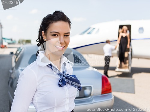 Image of Beautiful Stewardess Standing Against Limousine And Private Jet