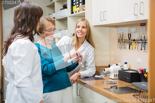 Image of Optician With Apprentices Repairing Glasses