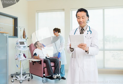 Image of Doctor Using Digital Tablet In Chemo Room