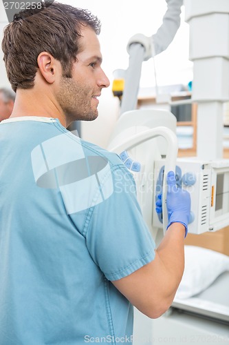 Image of Male Nurse Adjusting Xray Machine