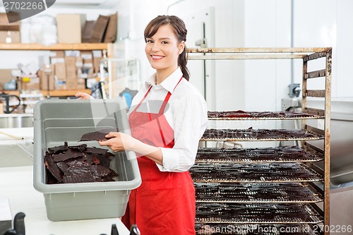 Image of Worker Holding Beef Jerky And Basket At Butcher's Shop