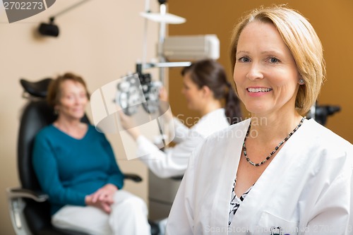 Image of Confident Optometrist With Colleague Examining Patient