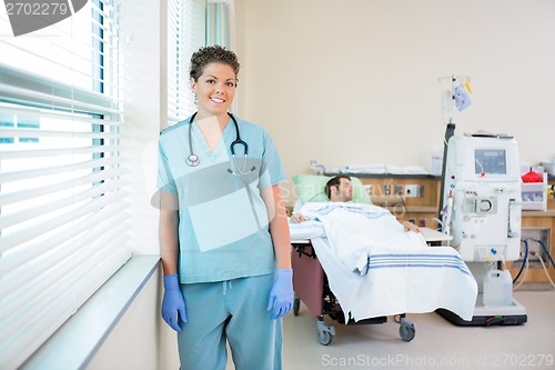 Image of Nurse With Patient Receiving Renal Dialysis In Background