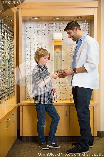 Image of Optometrist And Boy Holding Spectacles In Store