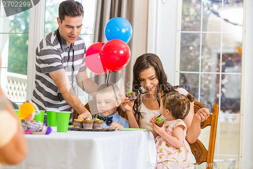 Image of Family Eating Cupcakes At Birthday Party