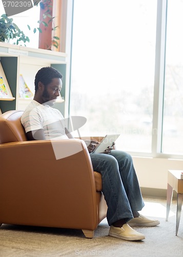 Image of Student Using Digital Tablet In Bookstore