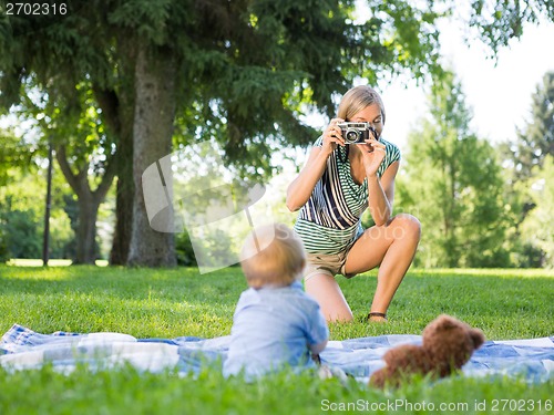 Image of Mother Photographing Baby Boy At Park