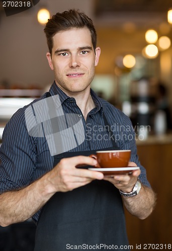 Image of Barista Standing in Cafe with Cup