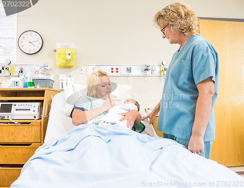 Image of Nurse Looking At Patient Feeding Milk To Babygirl