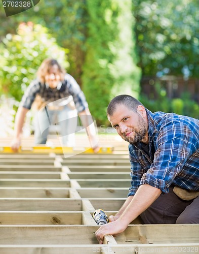 Image of Carpenter Holding Drill At Building Site