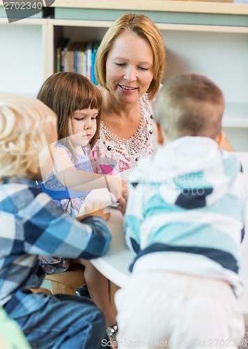 Image of Teacher And Students At Table In Library