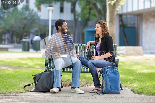Image of Students Sitting On Bench At University Campus