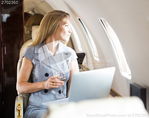 Image of Businesswoman Looking Through Window Of Private Jet