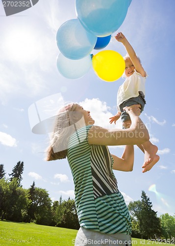 Image of Mother And Daughter Playing With Balloons In Park