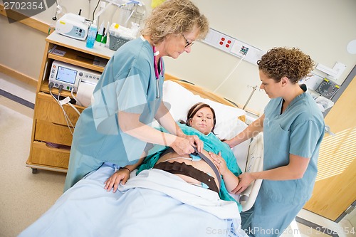 Image of Nurses Preparing Pregnant Woman For Fetal Heart Rate Monitor