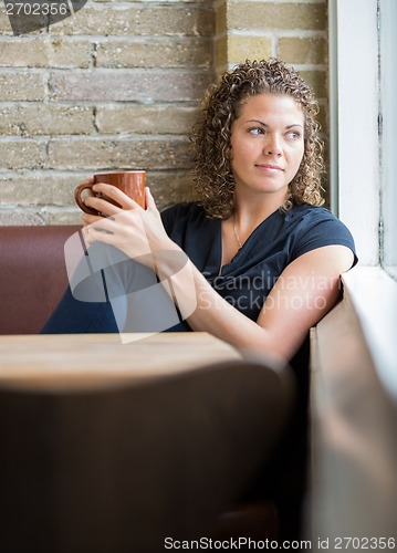 Image of Woman Looking Through Window In Cafeteria