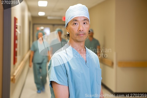 Image of Confident Doctor With Team Walking In Corridor