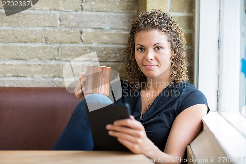 Image of Woman With Coffee Mug And Digital Tablet In Cafe