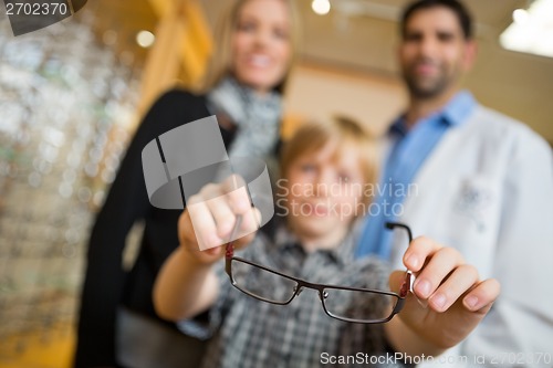 Image of Boy Showing Glasses With Mother And Optician In Store