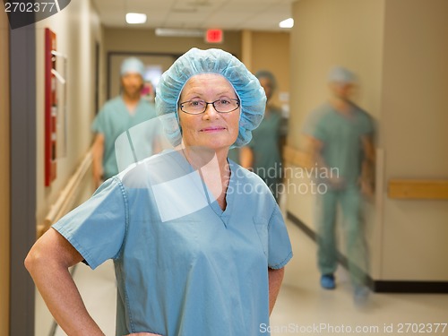 Image of Doctor With Team Walking In Hospital Corridor