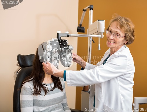 Image of Optometrist Adjusting Phoropter For Young Patient