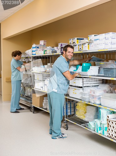 Image of Nurses Arranging Stock On Shelves In Storage Room