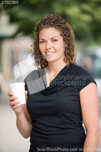 Image of Woman Holding Disposable Coffee Cup Outdoors