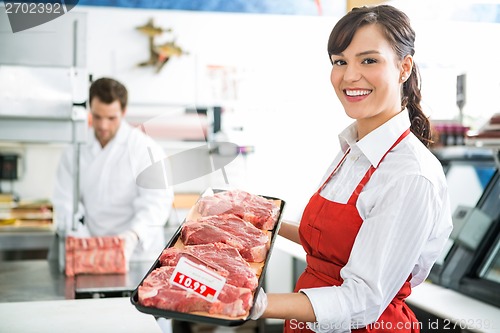 Image of Happy Butcher Holding Meat Tray In Store