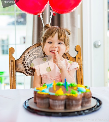 Image of Happy Girl Sitting In Front Of Birthday Cake