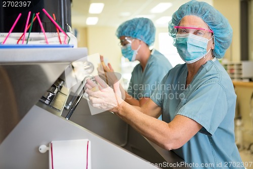 Image of Doctor Scrubbing Hands With Colleague