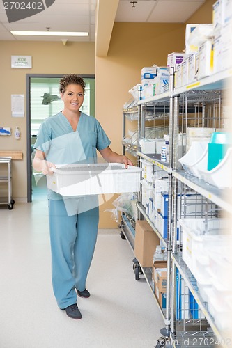 Image of Nurse Carrying Container In Hospital Storage Room