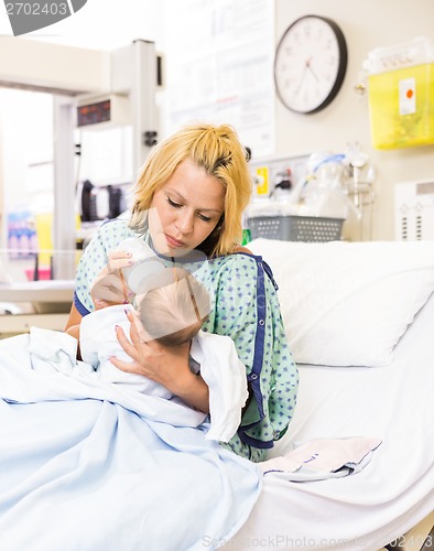 Image of Mother Feeding Milk To Baby Girl In Hospital Bed