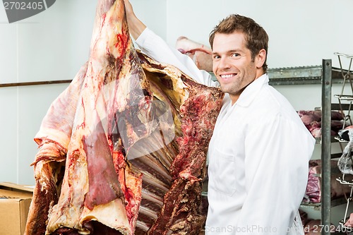 Image of Butcher Standing Beside Beef in Cooler