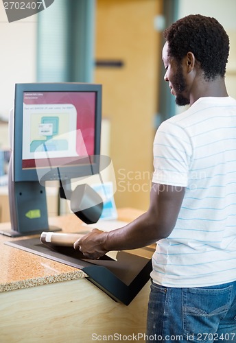 Image of Librarian Scanning Books At Bookstore Counter