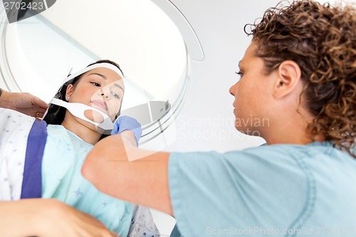 Image of Patient Looking At Nurse Adjusting Strap Before CT Scan