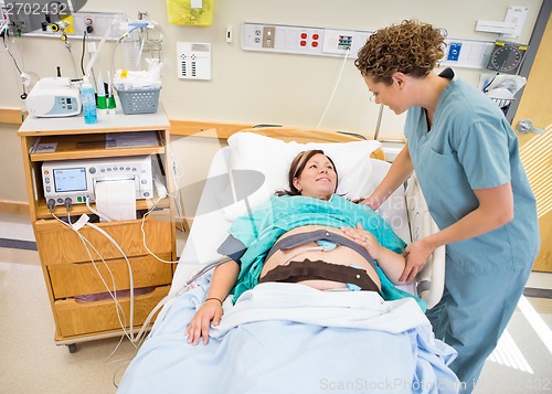 Image of Nurse Communicating With Pregnant Patient Lying In Hospital Bed