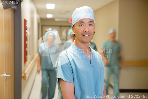 Image of Doctor With Medical Team Walking In Hospital Corridor