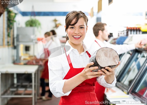 Image of Happy Female Butcher Holding Large Ham