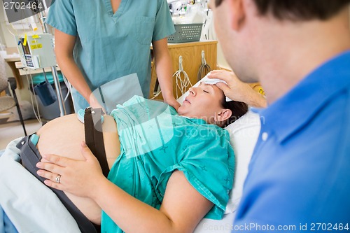 Image of Loving Husband Wiping Pregnant Wife's Forehead